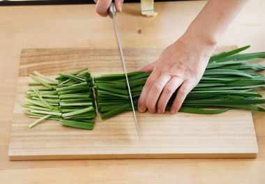 写真：にらを約4センチメートルの長さに切り、葉と根元部分を分けておく