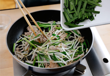 写真：にらの葉を加えてさっと炒め、塩とこしょうで味を調える