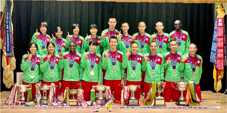 写真：数々のトロフィーや優勝旗と並ぶメンバー