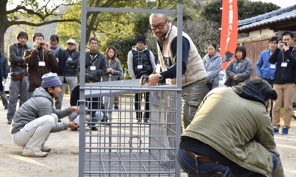 男性と箱わなの画像
