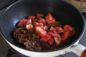 ざく切りにしたトマトを加える