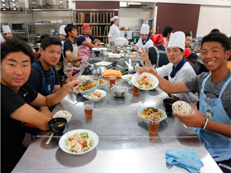 調理した食事を一緒に食べる選手と専門学校の生徒