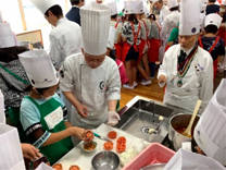 調理のコツを教わっている児童