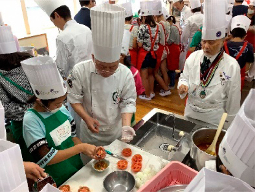 調理のコツを教わっている児童