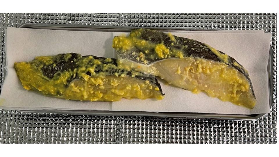トレーにのった味付けの魚の切り身2切れの写真。