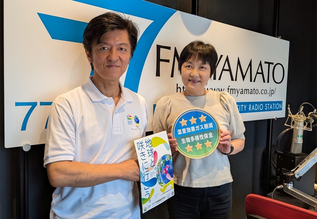 収録後に地方参事官とパーソナリティで園芸博のポスターを持っている写真