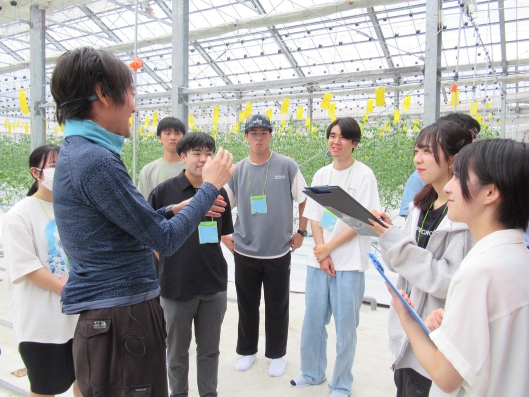 フィールドワークで学生たちに説明する澤井さんの写真です