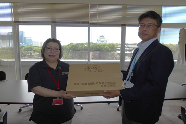 有江地方参事官（右）からフードバンクへの引渡し