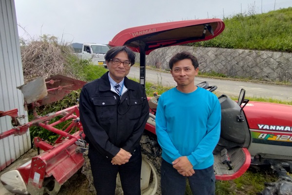 トラクターの前で男性二人