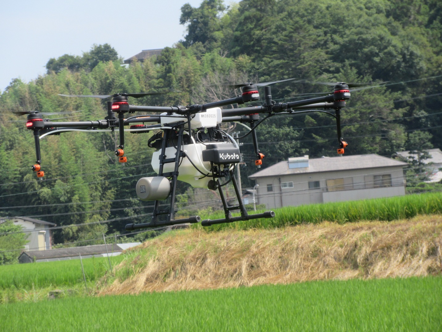 田の上を飛び回るドローン