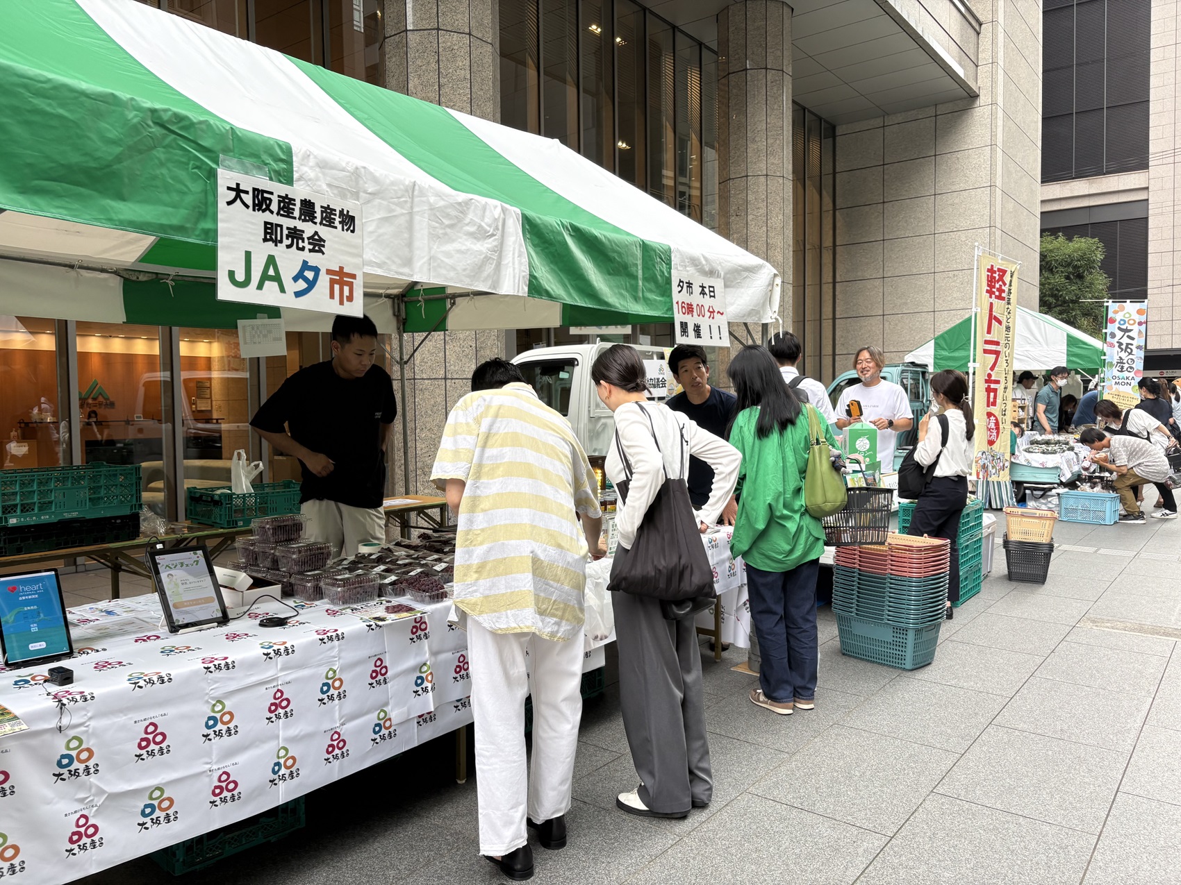 ビジネス街に新鮮な農産物や加工品が並び多くの人で賑わう会場