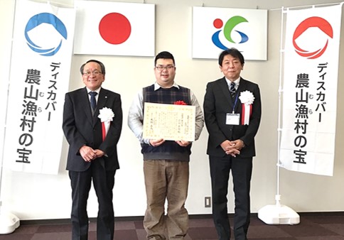 選定証を掲げる前川真司さん