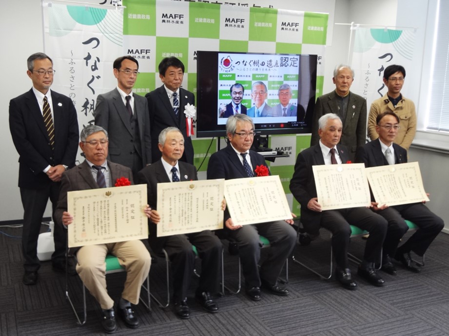 モニター画面を囲んで記念写真撮影