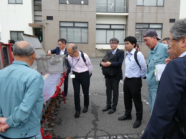 Ｖ直栽培用農機具の説明を受ける渡辺次長（中央左）市橋生産部長（右）奥平地方参事官（中央右）（10月15日撮影）